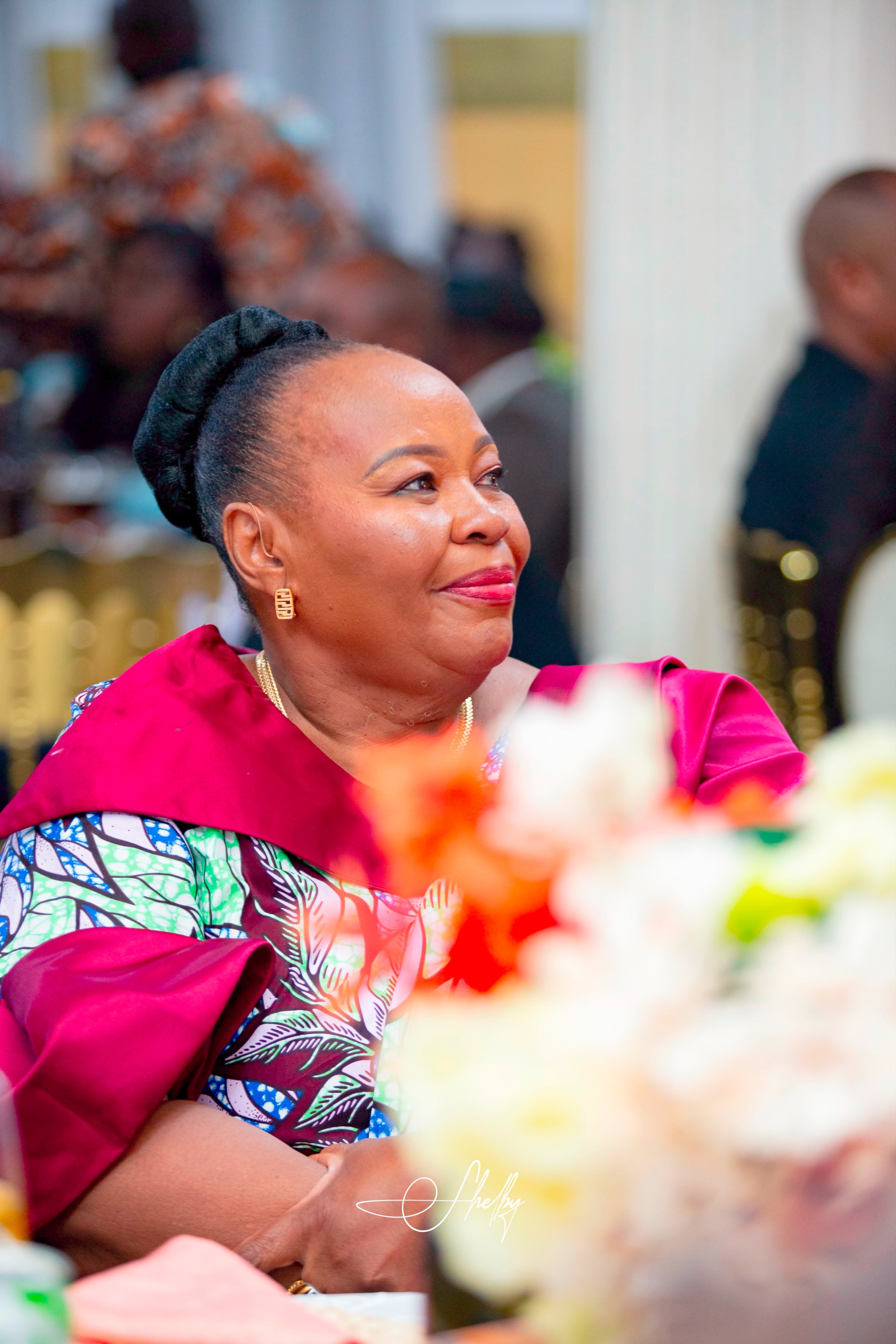 Family member in vibrant African print attire at the celebration